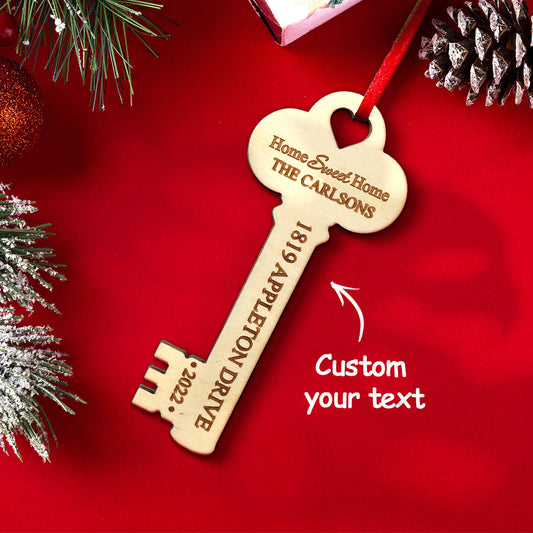 Personalized wooden key Christmas ornament, ideal housewarming gift, featuring custom text on a red ribbon.